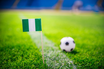 Nigeria national Flag and football ball on green grass. Fans, support photo, edit space