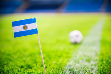 Obraz premium Argentina national Flag and football ball on green grass. Fans, support photo, edit space