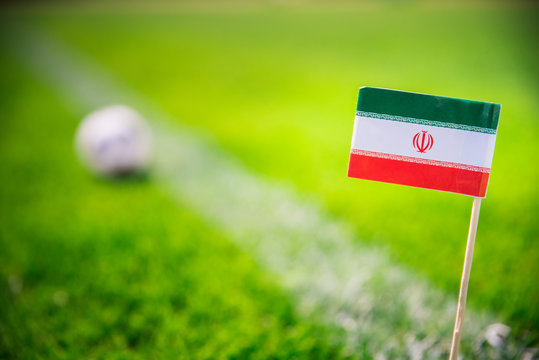 IR IRAN national Flag and football ball on green grass. Fans, support photo, edit space