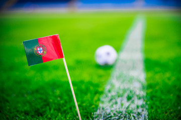 Obraz premium Portugal national Flag and football ball on green grass. Fans, support photo, edit space
