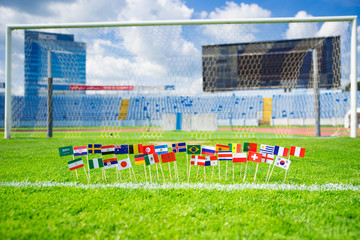 Fototapeta na wymiar Flags of all football nations on green grass. Football ball, Fans, support photo, edit space