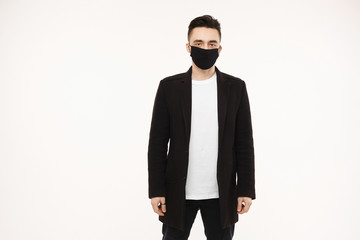 Obraz na płótnie Canvas Handsome young man in black protective mask isolated on white background. Healthy lifestyle concept. Seasonal illness, and seasonal flu concept. Men wearing medical mask to prevent infection