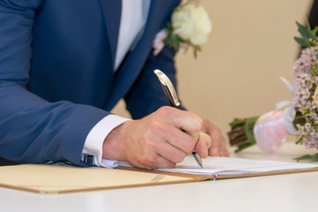 Groom signing a wedding contract