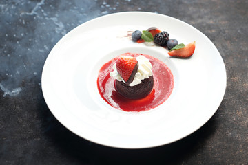 Chocolate cake with a liquid agent served with raspberry sauce.