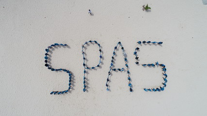 A collection of people form writing on the beach during the day.