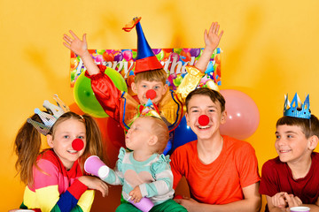 Clown child and joyful children at a festive event.