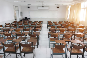 Fototapeta na wymiar Empty classroom with a lot of chair with no student. Empty classroom with vintage tone wooden chairs. Back to school concept.