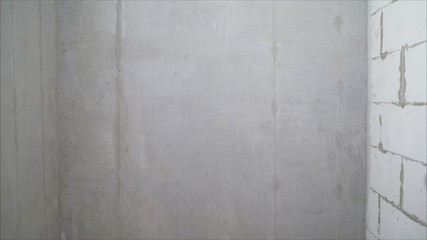 Concrete wall. Primed concrete wall. Repair work, priming and painting a bare concrete wall. Gray concrete wall texture background.