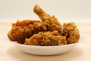 Fried chicken in  white plate on wooden table
