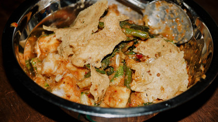 Close-up of Pecel - Traditional Javanese salad, consisting of mixed vegetables in a peanut sauce dressing, served with omelet.