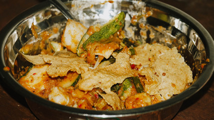 Close-up of Pecel - Traditional Javanese salad, consisting of mixed vegetables in a peanut sauce dressing, served with omelet.