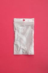 Empty transparent plastic zip lock bag with copy space on pink background, ziplock for medicines