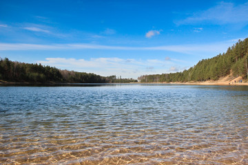 Ripples on the water surface. Clear shimmering water and view at its bottom. Lake view panorama.