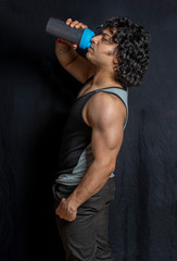 indian male bodybuilder drinking protein