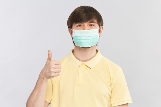 Man In Yellow Shirt And Protective Sterile Mask Showing Thumbs Up Gesture