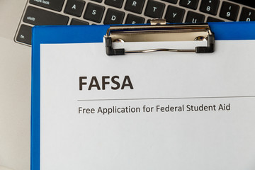 Fafsa. Student aid statement form and money on the tablet