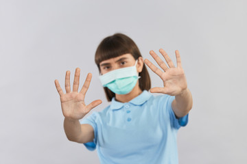 stop gesture and social distancing while covid-19 with woman in protection mask on background