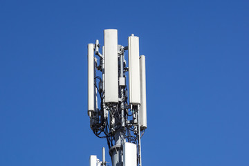 Close up white color antenna repeater tower on blue sky