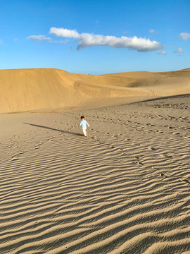 Toddler walking around the Dunes of Maspalomas, in Gran Canaria Island