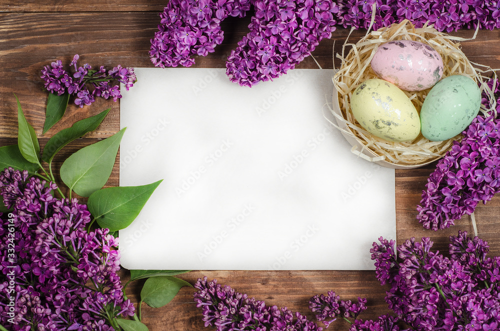 Wall mural easter eggs and fresh lilac flowers on a old wooden background