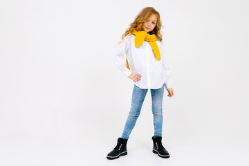 teenager model girl in a white shirt and jeans with a scarf and hat on a white isolated background