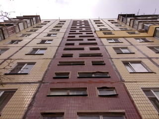 Bottom-up view on facade of old soviet multistorey typical concrete apartment.