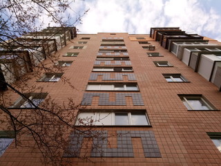 Bottom-up view on facade of old soviet multistorey typical concrete apartment.