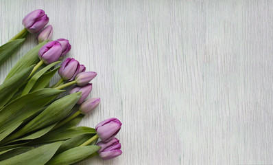 A bouquet of fresh tulips is on the table. Concept of a holiday greeting or gift