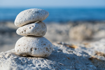 Zen pyramid from spa stones on a blurred sea background. Sea stones on the coast. Sea coast. Place for text. Sea view. A stone structure on the beach