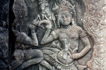 Fototapeta na wymiar Dancing woman on 12th century ruined relief of the Bayon temple, Cambodia. Historical artwork on column of Khmer landmark in Angkor. UNESCO world heritage site