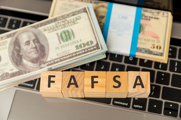 Fafsa. Student aid statement form and money on the tablet