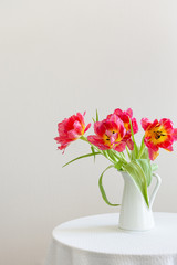 Spring flowers. Bouquet of red tulips in a vase on white background. Mother's Day and Valentines Day background. Side view, copy space