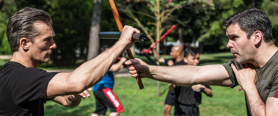 Large group of students practice filipino eskrima stick fight techniques