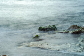 Long exposure sea and green moss stones. Mediterranean sea.