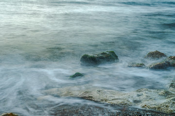 Long exposure sea and green moss stones. Mediterranean sea.