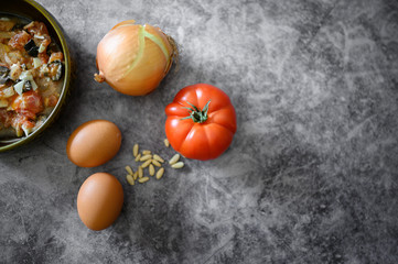 Delicious ingredients for a fresh salad. Onion,tomato,eggs and pine nuts together with a ready to...