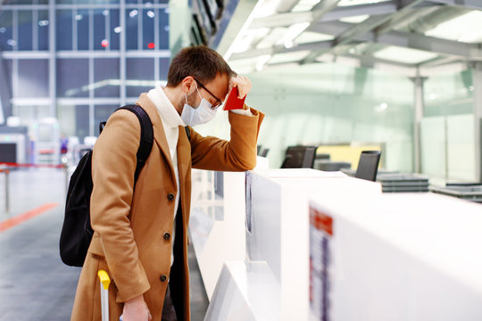 Man in mask stuck in empty airport in coronavirus quarantine isolation, waiting for departure, flight cancellation, pandemic infection worldwide spread, travel restrictions and border shutdown