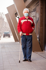 man with a cane in a protective mask