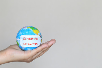 Coronavirus 2019-nCOV, Woman hand holding world or earth with wearing protective medical mask on white background, Healthcare and Safety concept
