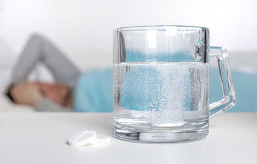 effervescent tablet falling in glass and a sick man with the covid-19 virus