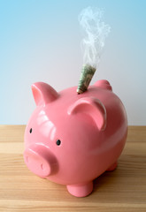 A piggy bank with smoking money.