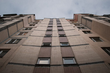 Bottom-up view on facade of old soviet multistorey typical concrete apartment.