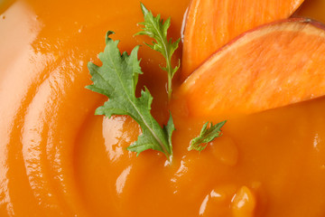 Sweet potato cream soup on whole background, close up