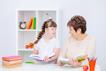 Girl with Down Syndrome works with her teacher at home