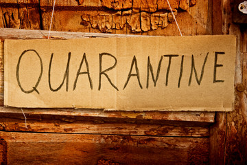 The inscription quarantine on cardboard close-up. Quarantine due to coronavirus. Quarantine closeup. Quarantine table hanging on the door handle