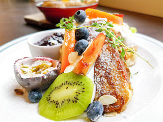 Delicious sweets French toasts with vanilla yogurt, blueberries jam and fresh fruits for a vitamin breakfast.