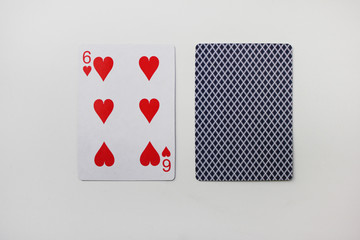 Six of hearts playing card with deck isolated on white. Playing cards image with 6 hearts laying on empty white table