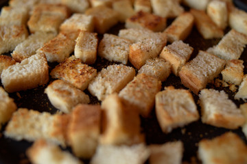 Rusks in the pan. Homemade toasted bread, croutons. Bread in salt, pepper, seasoning, crunchy salad.