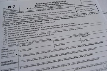 W7 tax form for American citizens, filling out a declaration and instruction. selective focus close-up.