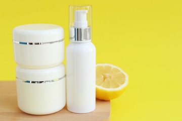 Jars with cream on a yellow background, space for text